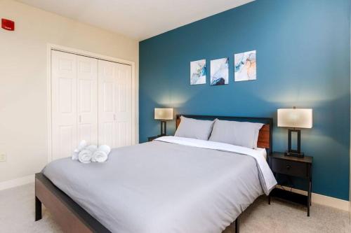 1 dormitorio con 1 cama blanca grande y pared azul en 1B1B Cozy Chic in DT Pittsburgh VALET GYM WIFI en Pittsburgh