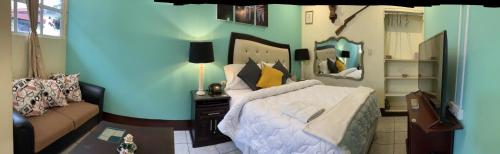 a bedroom with a large white bed and a couch at Hotel Vintage "Casa las Flores" in Quetzaltenango