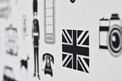 a wall with photographs of the united kingdom on it at Beaconsfield Hotel in London