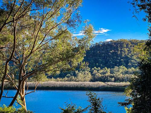 a view of a lake with trees and a mountain at Forgotten Valley Guesthouse in Gunderman