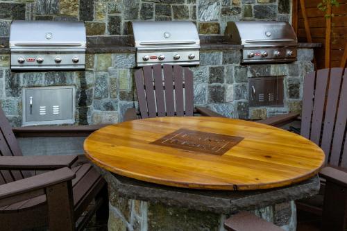 a wooden table with chairs and a stone stove at The Lake Motel in Lake George