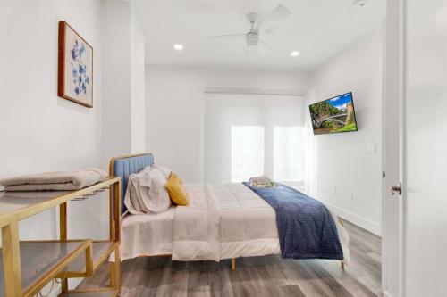 a white bedroom with a bed and a desk at Rhythm & Blues Free Park 2BD-2BTH Near EWR-Penn-Prudential in Newark