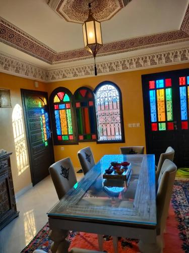 a dining room with a table and chairs and stained glass windows at Riad Appart Arwa in Marrakech
