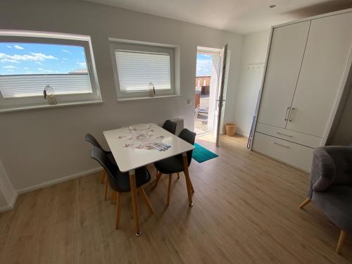 een kleine woonkamer met een tafel en stoelen bij Hafenloft App 4 in Norderney