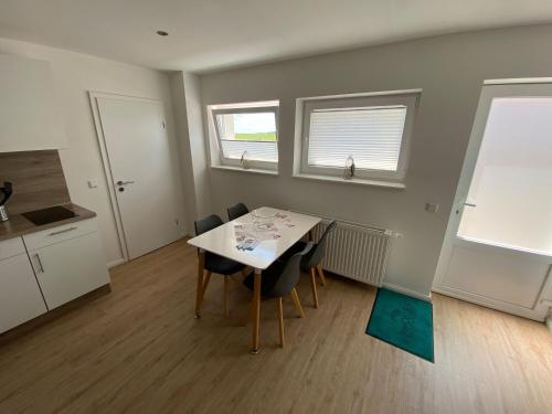 uma cozinha e sala de jantar com mesa e cadeiras em Hafenloft App 4 em Norderney