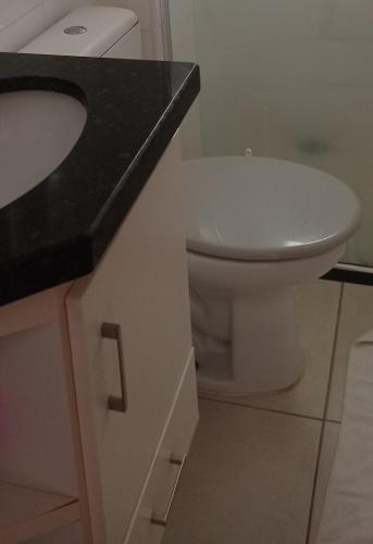 a bathroom with a white toilet and a sink at Apartamento aconchegante in Ribeirão Preto