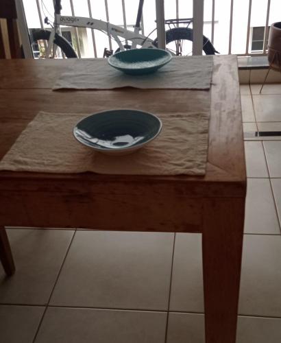 a wooden table with two plates on top of it at Apartamento aconchegante in Ribeirão Preto