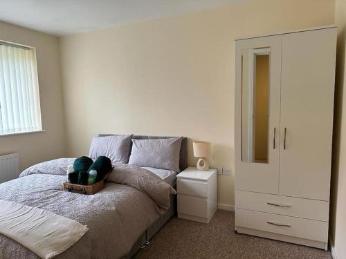 Rooms 7 minutes from Etihad في مانشستر: غرفة نوم مع سرير وخزانة ومرآة