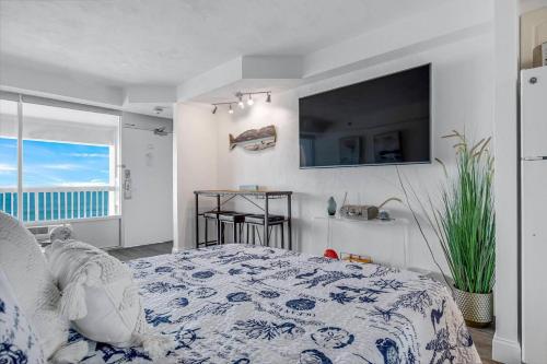 a bedroom with a bed and a television on the wall at Daytona Beach Resort Ocean Front Condo in Daytona Beach