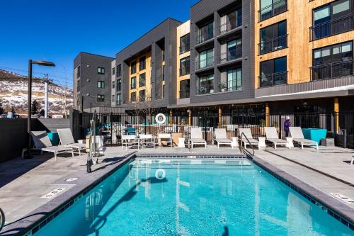 a swimming pool with chairs and a building at YotelPAD Park City Unit #432 in Park City