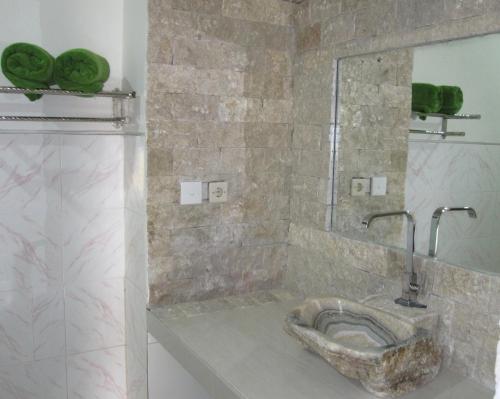 a bathroom with a stone sink in a shower at Galang Kangin Bungalows in Amed