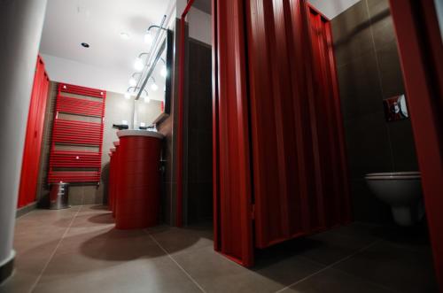 a bathroom with red stalls and a toilet at Main Square Hostel in Zagreb