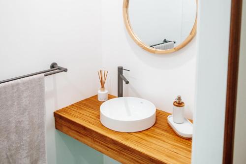 a bathroom with a white sink and a mirror at Paperbark Retreat in Cooktown