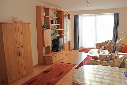 ein Wohnzimmer mit einem Sofa und einem TV in der Unterkunft Steife Briese in Dorum Neufeld