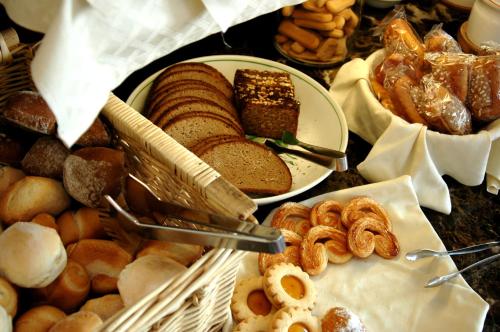 una mesa llena de diferentes tipos de pan y repostería en Hotel Capri Bardolino 3S, en Bardolino