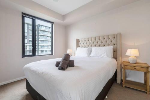 a bedroom with a large bed with a stuffed animal on it at Amazing Luxury Apartment & so close to the CBD - 01756 in Melbourne