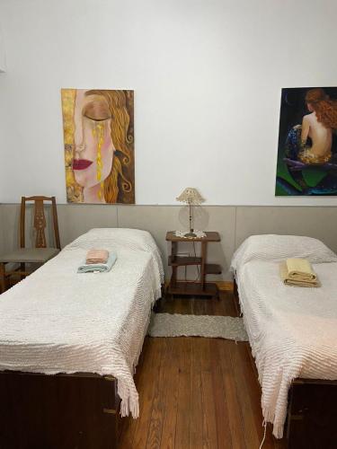 2 camas en una habitación con pinturas en la pared en El oasis de Cris en Mar del Plata