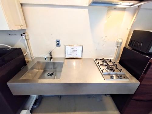 a kitchen with a sink and a stove at 酒と宿と不動産-yado- in Yokosuka