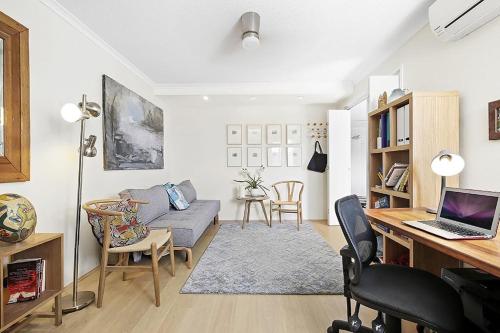 - un salon avec un canapé et un bureau avec un ordinateur portable dans l'établissement Impressive Centrally Located Penthouse, à Sydney