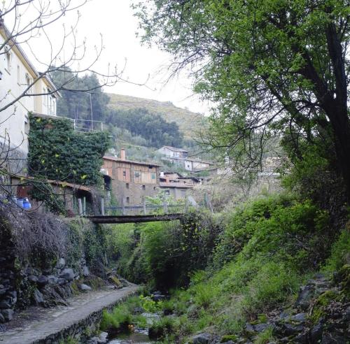 a bridge over a river in a small village at Casa Rural La Ortiga in Robledillo de Gata