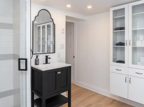 baño con lavabo negro y espejo en Cozy Cottage Style House, en Kitchener