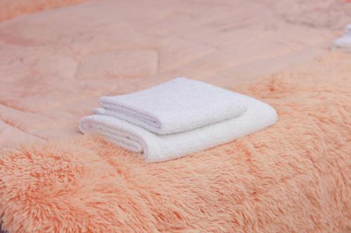 una pila de toallas sentadas encima de una alfombra naranja en Apart House en Türkistan