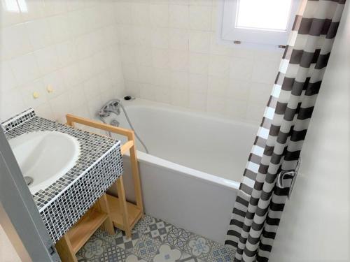 une salle de bain avec une baignoire et un lavabo dans l'établissement Maison de vacances près plage et commerces avec jardinet, parking privé et équipements complets - FR-1-22-165, à La Tranche-sur-Mer