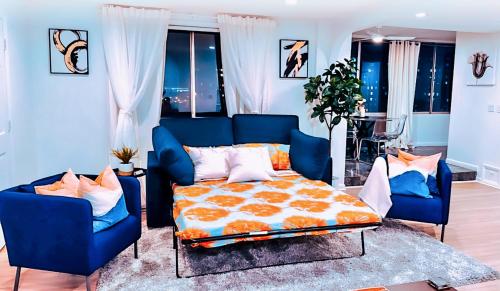 a bedroom with a bed and two blue chairs at Highrise luxury two bedroom condo in Downtown Atlanta within minutes!! in Atlanta