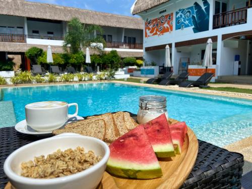 a table with a bowl of fruit and a cup of coffee at Amihan Resort in Panglao