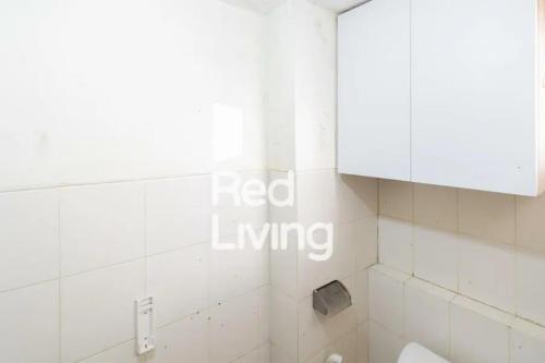 a bathroom with white tiled walls and a white cabinet at Apartemen Kemang View - Room 88 Tower Acasia in Jakarta
