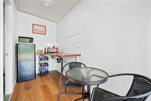 a room with chairs and a table and a counter at Litchfield Tropical Stay in Batchelor