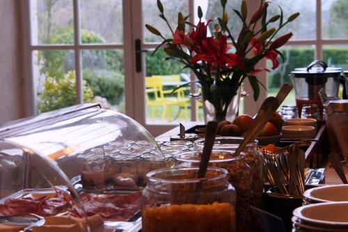 una mesa cubierta con comida y un jarrón de flores en Hotel Le Moulin du Château, en Saint-Laurent-du-Verdon
