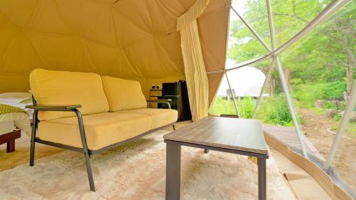 a living room with a couch and a table in a tent at glampark Otaru Hanaemi Hokkaido in Otaru
