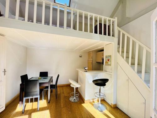 une salle à manger avec une table et une mezzanine dans l'établissement Maison Arcachon: proche centre, plage et parc. Terrasse ensoleillée, 2 mezzanines, animaux acceptés. - FR-1-433-101, à Arcachon