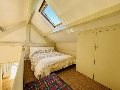 - une petite chambre mansardée avec un lit et une fenêtre dans l'établissement Maison Arcachon: proche centre, plage et parc. Terrasse ensoleillée, 2 mezzanines, animaux acceptés. - FR-1-433-101, à Arcachon