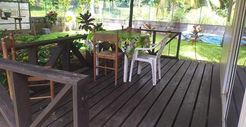 una terraza de madera con mesa y sillas. en VAIHEI 22 en Puahua