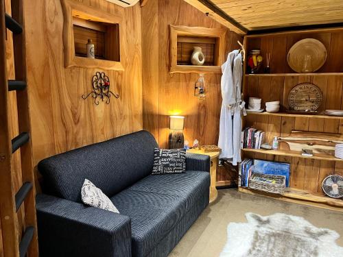 a living room with a couch and wooden walls at Tree House Lodge Bed & Breakfast in Cheviot