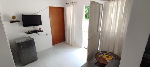 a room with a television and a chair and a door at Guest House Villa Hortensia in Santa Marta