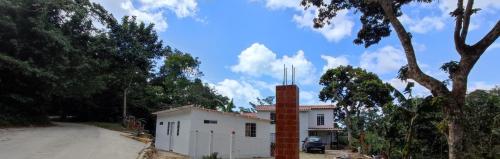 a white house with a chimney on a dirt road at Guest House Villa Hortensia in Santa Marta