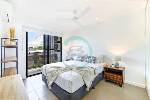 a bedroom with a large bed and a balcony at ZEN NOMAD 2-BR Nightcliff Apt Near Markets & Shops in Nightcliff