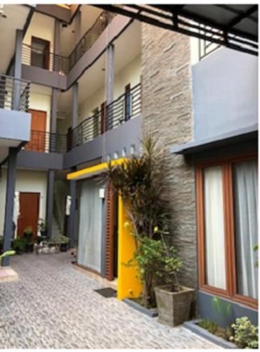 un edificio de apartamentos con puerta amarilla y patio en The Risen Kost, en Yakarta