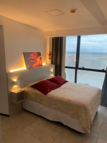 1 dormitorio con 1 cama y vistas al océano en Barra Home Stay - Beira mar - 2 QUARTOS, en Recife