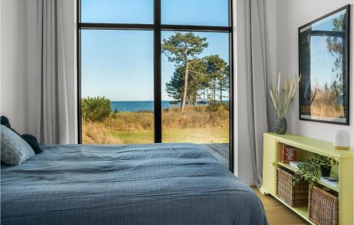 a bedroom with a large window with a view of the ocean at Stunning Home In Kalundborg With House Sea View in Kalundborg