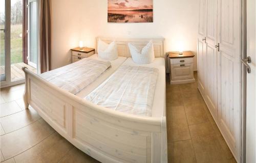 Beautiful Apartment In Rechlin With Sauna في ريكلين: سرير ابيض كبير في غرفة مع مواقف ليلتين