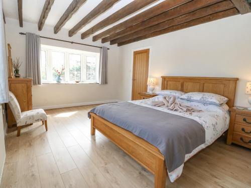 a bedroom with a bed and a chair and a window at Glan Felin in Aberdaron