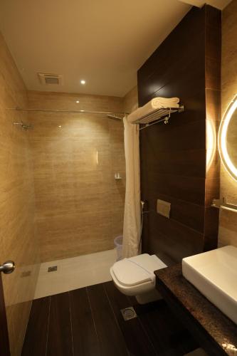 a bathroom with a toilet and a shower and a sink at Sri Ambal Grand in Virudunagar