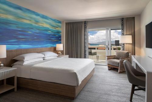 a hotel room with a bed and a view of the ocean at Sheraton Waikiki Beach Resort in Honolulu