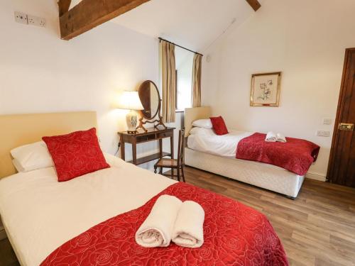 una camera da letto con due letti con lenzuola rosse e bianche di The Dairy a Corwen