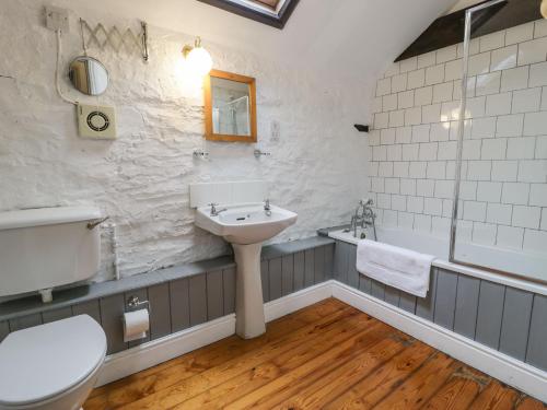 uma casa de banho com um lavatório, um WC e uma banheira em The Corn Store em Corwen