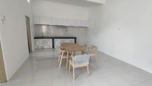 a kitchen with a table and chairs in a room at Gopeng Senada Holiday House in Gopeng